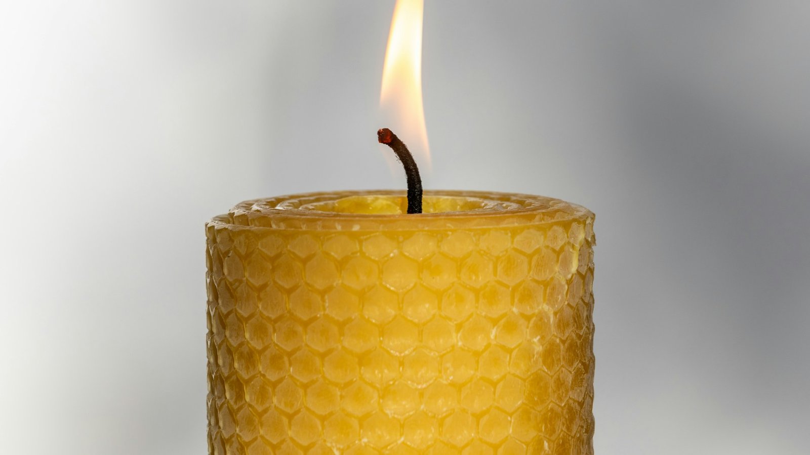 Close view of a beeswax candle showing its natural wax texture