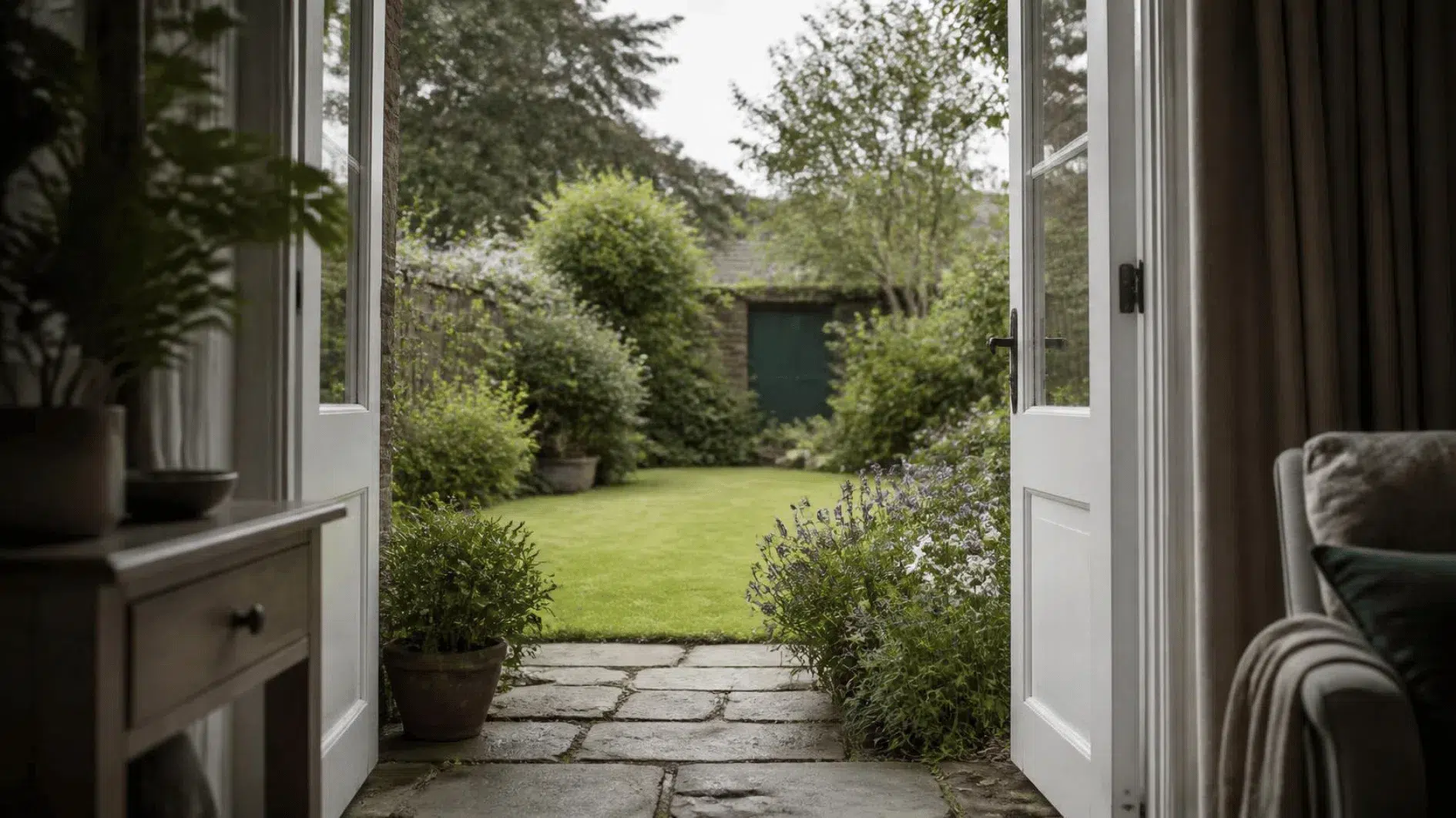 Open doorway in a British home overlooking modest green garden in gentle natural daylight